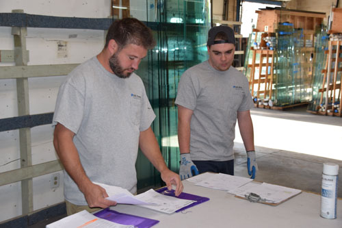 Two L&L Glass employees reviewing installation paperwork  